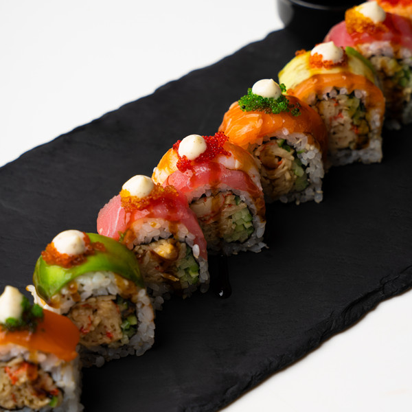 Πολύχρωμα sushi rolls με σολομό, τόνο και αβοκάντο για ένα ρομαντικό βραδινό στο σπίτι.