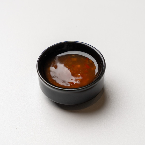 Sweet Chili sauce σε μαύρο μπολ, η γλυκοκαυτερή σάλτσα του Asian House.