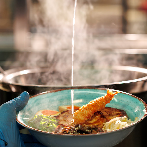 Προετοιμασία ζεστού ramen με γαρίδα και χοιρινό στην κουζίνα του Asian House.